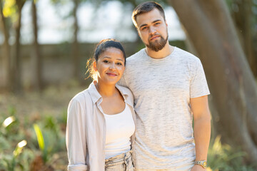 Obraz premium Happy multi-ethnic couple posing together in a park
