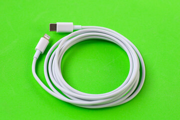 Cable with Type-C connector insulated, charging cable coiled on a green background.