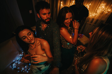 A group of friends enjoys a fun and festive birthday celebration at home, singing, dancing, and...