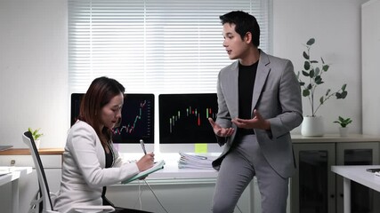 Business colleagues discussing stock market charts on computer screens. - Powered by Adobe