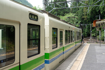 Eizan Railway train departs Demachiyanagi Station, heading into scenic northern Kyoto hills.