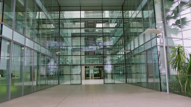 Panning shot of empty modern glass office building with foyer and stairs - shot in slow motion