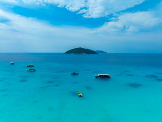 Aerail view of  tourist boat with green forest  island and the sea. natural ecosystems of forests in the oceans travel holiday concept