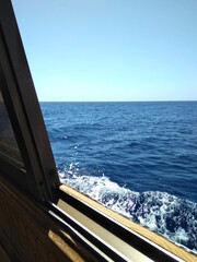 view from the porthole window of a cabin on a yacht ship boat to the horizon blue sea ocean water...