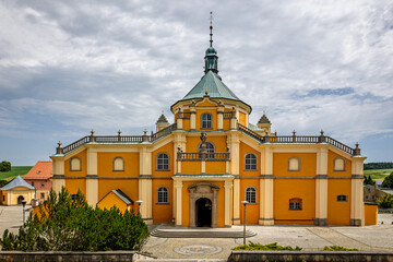 Basilica of the Visitation in the town of Wambierzyce. A Baroque basilica in Wambierzyce, Poland. A beautiful church in gold, yellow, and orange.