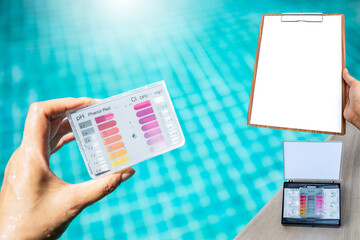 Swimming pool water testing test kit in girl hand with blank report paper on wooden clipboard over...