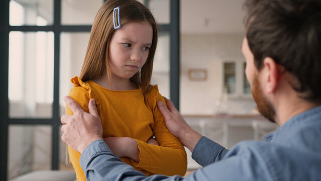 Stressed Caucasian family argument guilty man father male calming down touch angry little girl offended child daughter kid being stubborn at home. Caring dad apology asking for forgiveness conflict - Powered by Adobe