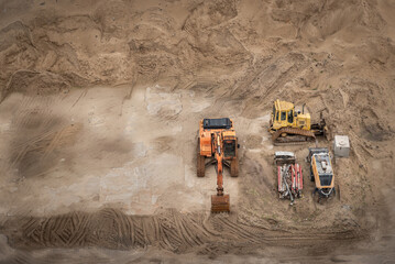 Excavator and bulldozer at earthworks, aerial viev