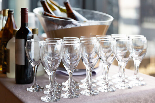 パーティー会場内のドリンクテーブルに並ぶワイングラスとボトル