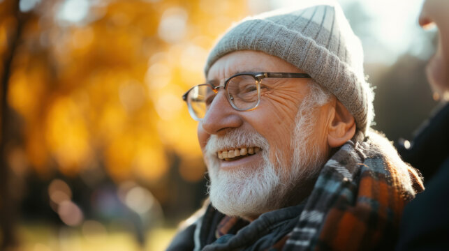 A cheerful senior man with a warm smile enjoying a sunny autumn day outdoors, showing positivity and joy.