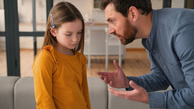 Angry Caucasian man guy speak shouting at guilty daughter little kid family conflict at home annoyed parent father punish naughty little child girl quarrel male dad taking away mobile phone discipline - Powered by Adobe