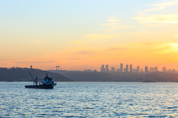a fishing boat and skyscrapers of istanbul and bosphorus in istanbul, turkey