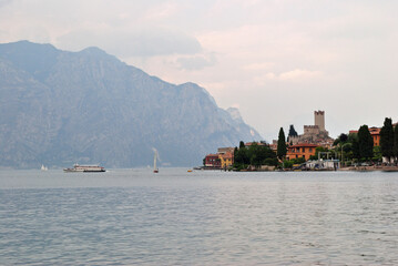View of Lake Garda with Mountains and Town of Malcesine with Boats and Cloudy Sky