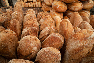 Freshly baked batard loaves, oval-shaped, wider and shorter than a baguette, with tapered ends.