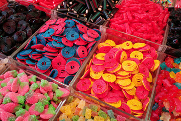 Bulk bins filled with an assortment of colorful, chewy individual pieces of candy.
