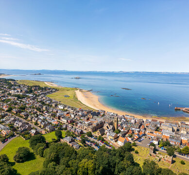 Aerial view of golden sands meet the azure sea, cradling the charming town of North Berwick under a clear sky, North Berwick, Scotland, United Kingdom.