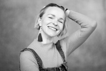 woman smiling in a black-and-white portrait, her hand running through her hair