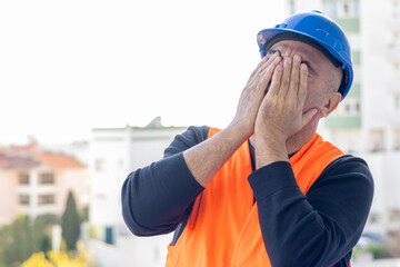 Tired and exhausted mechanical technician or building contractor. Bad news triggering headache