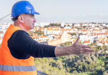 Joyful civil engineer, his arms outstretched, enjoying the panoramic view of a city