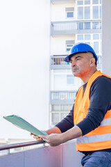 Construction engineer or building contractor wearing a blue protective helmet at work. Copy space