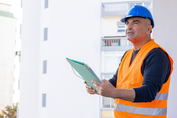 Construction engineer or building contractor wearing a blue protective helmet at work. Copy space