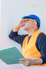 Tired and exhausted mechanical technician or building contractor. Bad news triggering headache