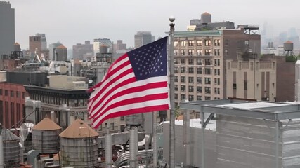 Aerial view of the American flag flying above New York City. Shot on an overcast morning in Manhattan. - Powered by Adobe
