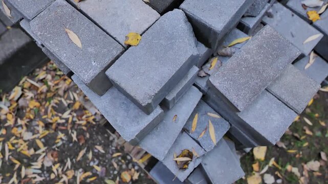 Close-up from above shows contrast between rigid blocks and soft autumn leaves