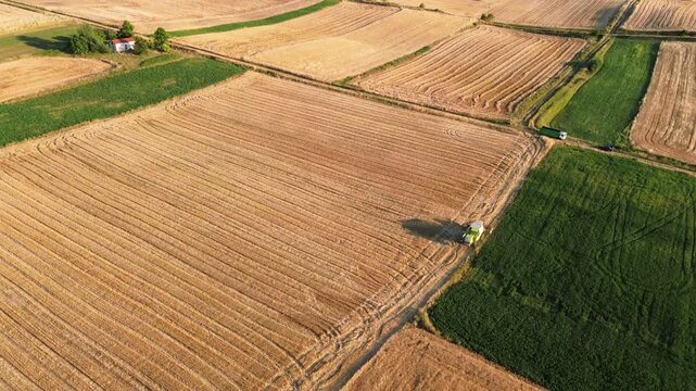 Agriculture fieldwork hay mower tractor tedder swather windrower field rural village, aerial drone