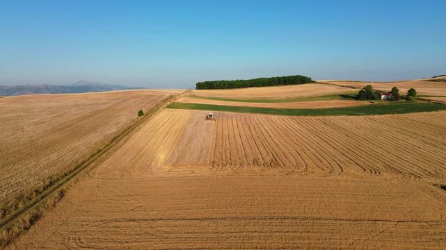 Agriculture hay mower tractor tedder modern field work rural village, aerial drone fieldwork labour
