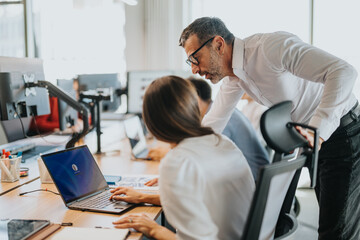 Business people working together in an open office space, focusing on teamwork and collaboration. A...