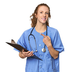 Nurse with report in studio smiling and pointing aside, showing something at blank space.