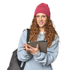 Redhead student with tablet and backpack, studio scene