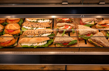 Fresh assorted sandwiches on display in bakery showcase