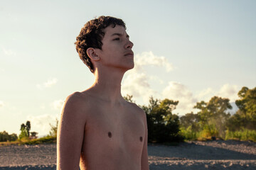 Hopeful teenager looking up at the sky, dreaming of the future. Concept of ambition, aspiration,...