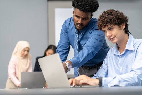 Diverse tech team meeting on software project, mentor guiding coworker on laptop, teamwork development using collaboration tools, modern technology, app design, dev training and enterprise SaaS team