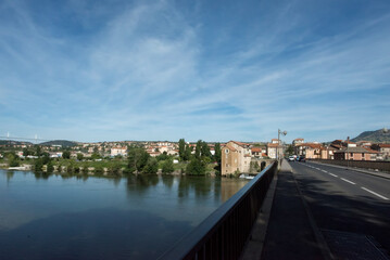 Fototapeta premium The city of Millau, France on the Tarn river. In the distance the Millau Viaduct can be seen.