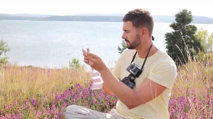 Photographer examining analog retro film samples in natural setting 