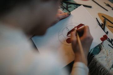 Close-up view of a person delicately painting on a white canvas, showcasing creativity,...