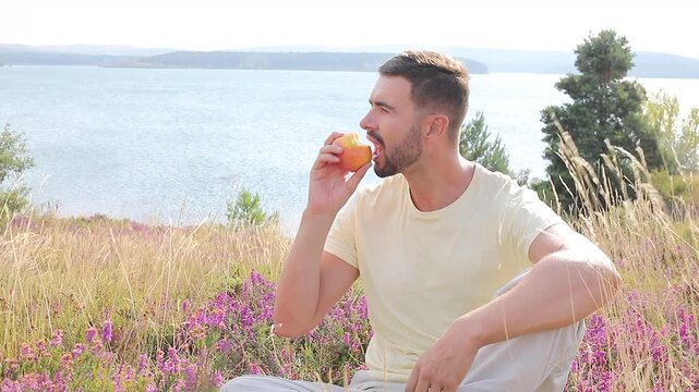 Video of healthy man eating an apple in nature 