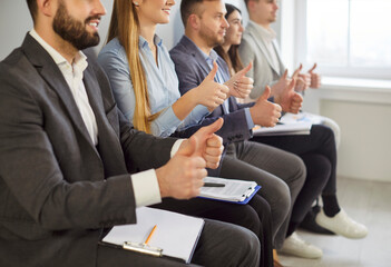 Happy diverse employees workers showing thumb up to recommend good quality company service, smiling colleagues celebrate shared business success or victory in office, satisfied give best feedback 