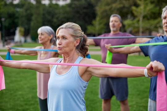 Mature people exercising with resistance band at park