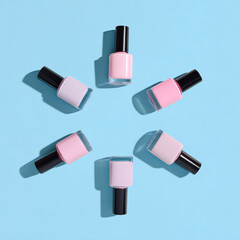 Obraz premium Soft pastel nail polish bottles arranged in circular pattern on vibrant blue background, showcasing minimalistic and luxurious aesthetic. colors evoke sense of calm and elegance
