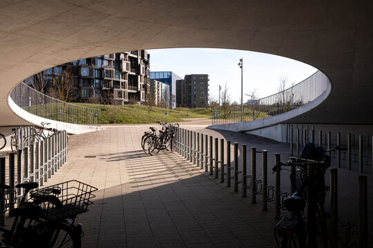 Circular ceiling opening with bicycle parking and new residential buildings in Copenhagen, Denmark, highlighting integration of soft mobility and urban ecological design systems