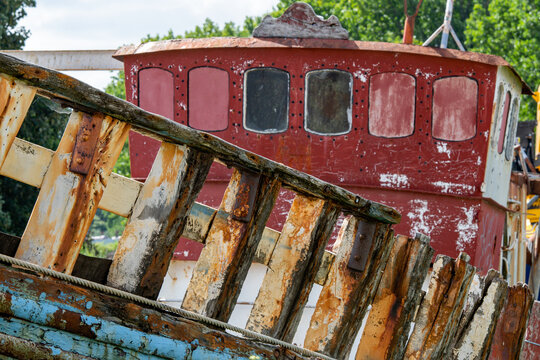 A wooden boat in a poor state with rotting wood. Maritime and boating image. 
