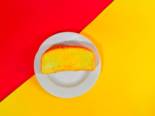 A slice of whole wheat bread with soft butter ready to be enjoyed for breakfast. Isolated background and close-up shot.