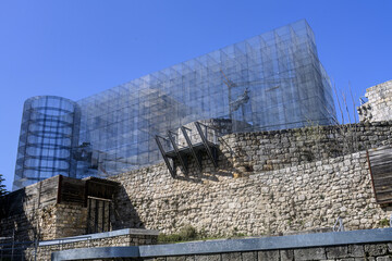 Contemporary metal facade on ancient castle foundation