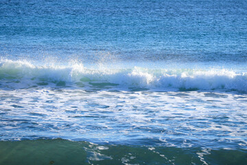 Waves breaking on the shore on the beach