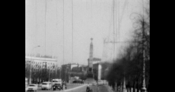 Driving along the wide avenue to the spire of the eternal flame monument. Traffic on a busy city road. Archive video of Minsk in the 1970s, Belarus