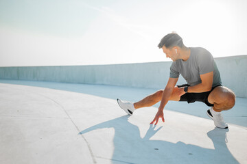 Man stretches during a morning workout on a sunny urban rooftop in the city
